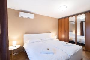 1 dormitorio con 1 cama blanca y 2 toallas en Boutique House Rustikana by Locap Group, en Izola