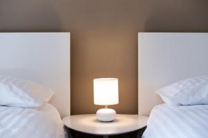 una lámpara blanca sentada en una mesa junto a dos camas en Boutique House Rustikana by Locap Group en Izola