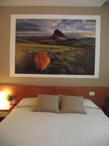 1 dormitorio con una pintura en la pared sobre una cama en La Corte Albergo, en Desio