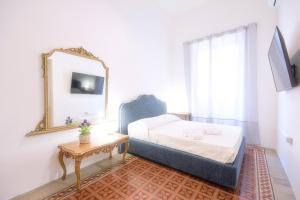 a bedroom with a bed and a mirror and a table at Right House via Sulis 23 - Best Neighborhood in Town in Cagliari