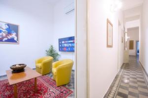 a hallway with two yellow chairs and a table at Right House via Sulis 23 - Best Neighborhood in Town in Cagliari