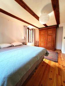 Schlafzimmer mit einem Bett mit blauer Decke in der Unterkunft Gite classé "Le tilleul" in Colmar