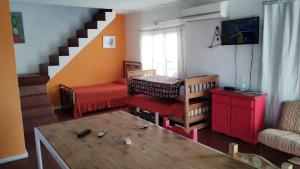 una sala de estar con una escalera y una habitación con una mesa en La Obra en Tandil