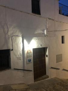 un edificio blanco con puerta y pared en Apartamentos Casa la Costanilla, en Vejer de la Frontera