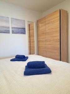 2 cuscini blu posti sopra un letto di Apartment House Bucul a Mali Lošinj (Lussinpiccolo)