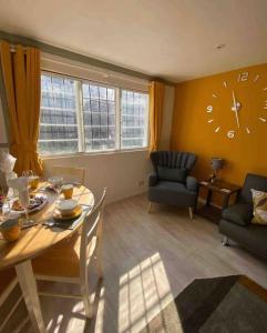 een woonkamer met een tafel en een klok aan de muur bij Rye- Tillingham Rye - LOCATION LOCATION LOCATION! in Rye