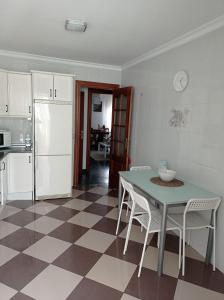 een keuken met een tafel en stoelen en een koelkast bij Casa en casco urbano de Riogordo in Ríogordo