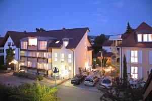 eine Gruppe von Gebäuden mit Autos auf einem Parkplatz in der Unterkunft Akzent Hotel Atrium Baden in Bad Krozingen