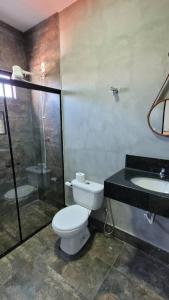 a bathroom with a toilet and a shower and a sink at Rio Quente Pousada do Charme in Rio Quente