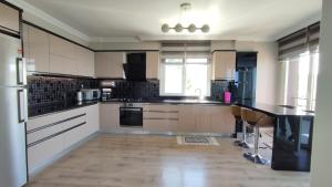 a kitchen with white cabinets and a black counter top at GARDEN PALACE VILLA in Trabzon