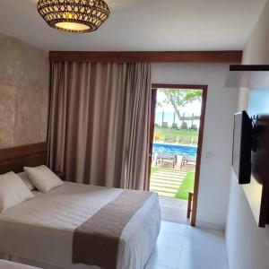 a bedroom with a bed and a sliding glass door at Aquarela Praia Hotel in Arraial d'Ajuda