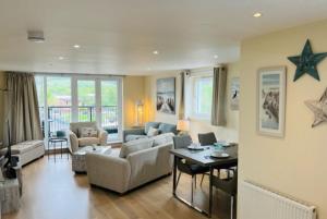 ein Wohnzimmer mit einem Sofa und einem Tisch in der Unterkunft Riverside View Penthouse in Balloch, Loch Lomond in Balloch