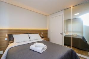 a bedroom with a bed with two towels on it at Wynn Residencial - 1002 in Caxias do Sul