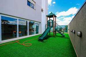 um parque infantil num edifício com relva verde em Wynn Residencial - 1002 em Caxias do Sul