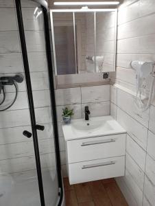 a bathroom with a sink and a mirror at Domki U Wojtka w Niechorzu in Niechorze