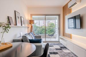 a living room with a table and chairs and a window at Trend Nova Carlos Gomes - 406 in Porto Alegre
