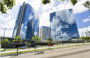 two tall glass buildings in a city with a street at Trend Nova Carlos Gomes - 406 in Porto Alegre