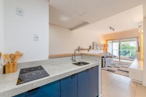 a kitchen with blue cabinets and a sink at Trend Nova Carlos Gomes - 406 in Porto Alegre