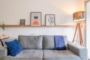 a living room with a gray couch with blue pillows at Trend Nova Carlos Gomes - 406 in Porto Alegre