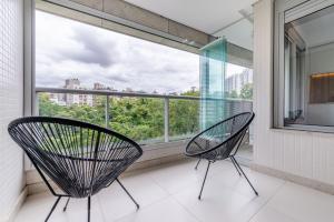 two chairs on a balcony with a large window at Trend Nova Carlos Gomes - 406 in Porto Alegre