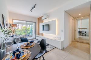 a dining room with a table and chairs and a tv at Trend Nova Carlos Gomes - 406 in Porto Alegre