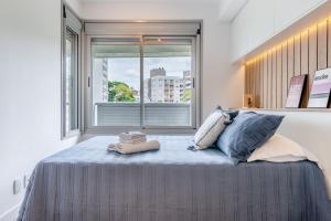 a bedroom with a bed with two pillows and a window at Trend Nova Carlos Gomes - 406 in Porto Alegre +27 photos