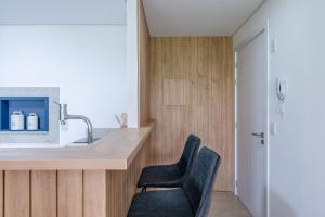 a kitchen with two black chairs and a counter at Trend Nova Carlos Gomes - 406 in Porto Alegre