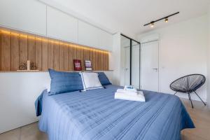 a bedroom with a blue bed and a chair at Trend Nova Carlos Gomes - 406 in Porto Alegre