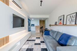 a living room with a couch and a tv at Trend Nova Carlos Gomes - 406 in Porto Alegre