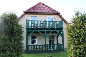 une maison avec un balcon au-dessus dans l'établissement Landsitz Rügen, à Glowe