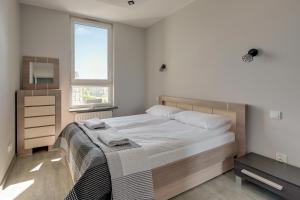 Un dormitorio con una cama grande y una ventana en Wave Apartments - Solvo 2 en Gdansk