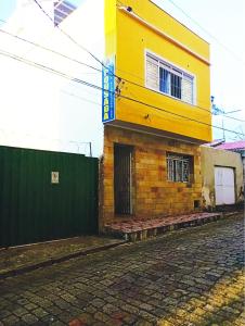 a yellow building on a street next to a building at Pousada Jesus Misericordioso in Aparecida