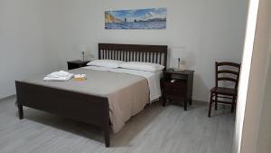 um quarto com uma cama grande e uma cadeira em Holiday Home Tarinuzza em Lipari