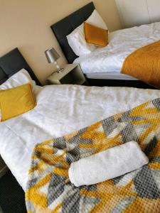 ウォルヴァーハンプトンにあるGoldthorn Wolverhampton sleeps 5 long term comfortably and familiesの毛布付きの客室内のベッド2台