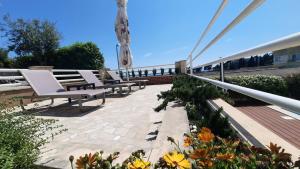 a row of benches on a patio with flowers at SEA VIEW- spacious apartment with shared pool in Split