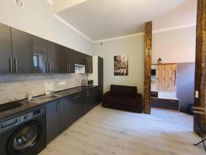 a kitchen with a washing machine and a couch at Linden apartment with Air condition in Budapest
