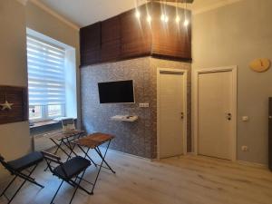 a room with a table and chairs and a tv at Linden apartment with Air condition in Budapest