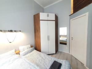 a bedroom with a white cabinet and a bed at Linden apartment with Air condition in Budapest