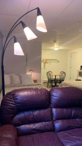 un soggiorno con divano in pelle e tavolo di Motel Des Cascades a Baie-Saint-Paul