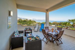 balcón con mesa, sillas y vistas al océano en Villa DellAcqua, en Alcamo Marina