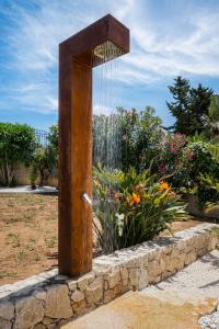 una estructura de madera en un jardín con una fuente en Villa DellAcqua, en Alcamo Marina