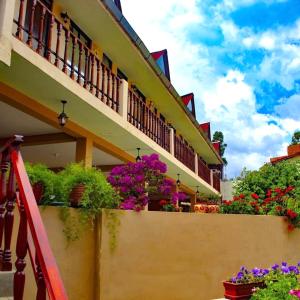 a balcony with flowers on the side of a building at Mi Pueblito Lodge in Huancayo +10 photos
