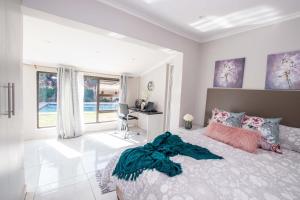 a bedroom with a bed with a blanket on it at Prestigious Apartments in Fourways