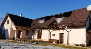 een huis met witte muren en bruine daken bij Prázdninový byt Lýdia in Lopej