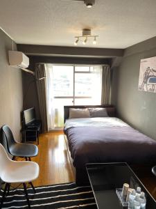 a bedroom with a bed and a table and a chair at Dazaifu - Hotel - Vacation STAY 58481v in Dazaifu