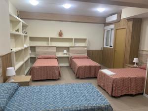 a room with three beds in a room at Hostal Juan XXIII in San Sebastián de los Reyes