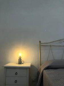 a bedroom with a bed and a lamp on a dresser at Casa Fortuna in Cisternino