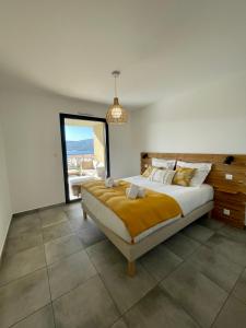 a bedroom with a large bed and a large window at Superbe T3 NEUF VUE MER in Propriano