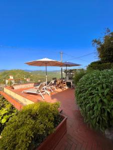 un patio con mesa, sombrilla y sillas en Collimare Rooms & Sailing near 5 Terre, en Vezzano Ligure
