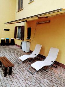 2 weiße Stühle und ein Tisch im Innenhof in der Unterkunft Residence SANTA CROCE Delebio Provincia di Sondrio in Sondrio